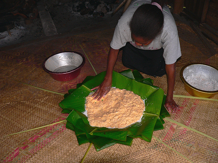 The leaves are folded and splashed with coconut milk before the banana paste is added. People often add pieces of meat on top of the laplap.